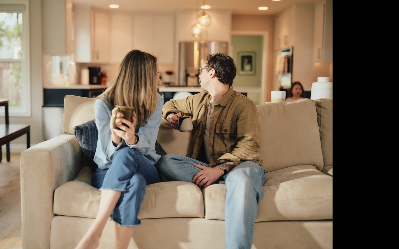 Dual-income millennial couple talking over coffee at home after a midyear job change